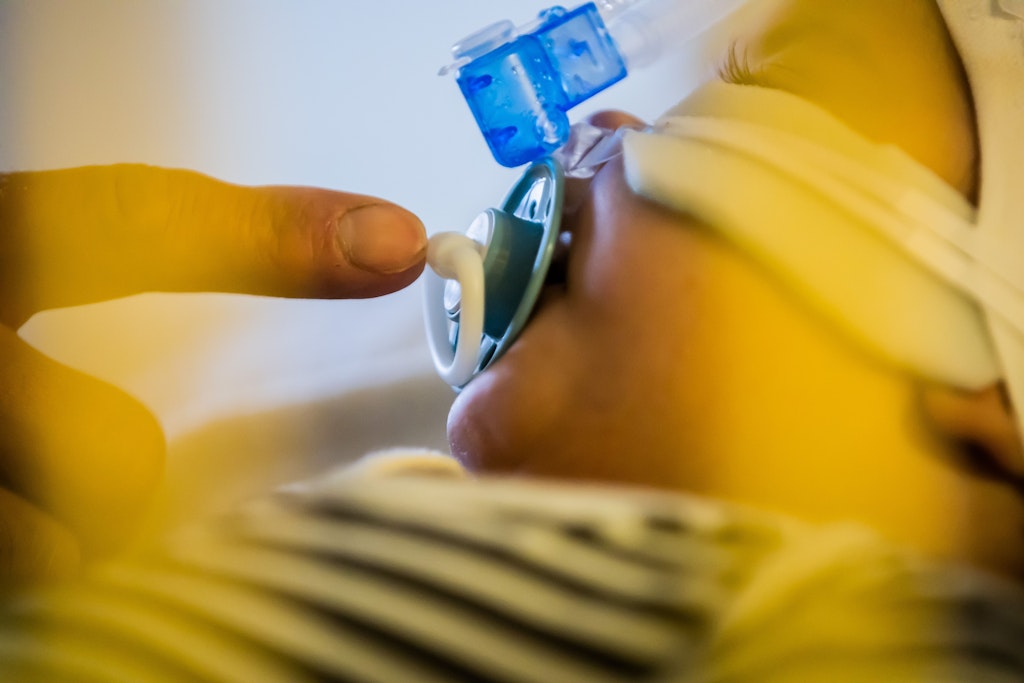 Vater Ziyad Salem betreut seinen achteinhalb Monate alten Sohn Omran Salem, der mit einem Atemwegsinfekt auf der Intensivstation der Kinderklinik des St. Joseph-Krankenhauses liegt und non-invasiv beatmet wird (CPAP-Beatmung). 