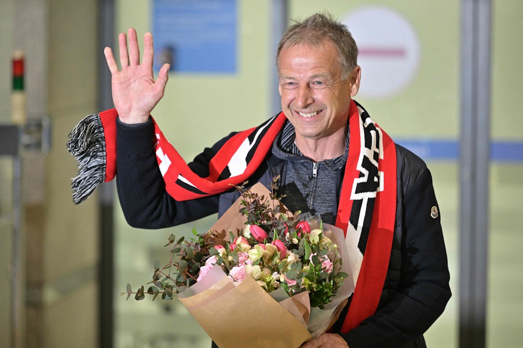 Herthas ehemaliger Trainer Jürgen Klinsmann bei der Ankunft in Südkorea. Zur Begrüßung bekam er einen bunten Blumenstrauß.