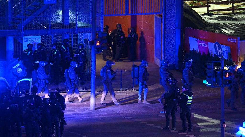 Polizisten in Spezialausrüstung sind in Hamburg am Tatort im Einsatz.