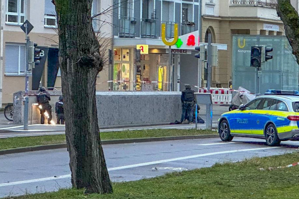 Polizisten stehen in Spezialausrüstung vor der Apotheke.