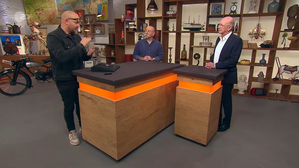 „Bares für Rares“-Experte Sven Deutschmanek (l.) begutachtet den alten Zeitmesser von Norbert (r.).
