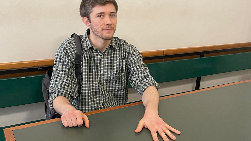 Das war im Februar: Klima-Kleber Henning Jeschke sitzt festgeklebt an einem Tisch in einem Raum des Amtsgerichts Tiergarten. 