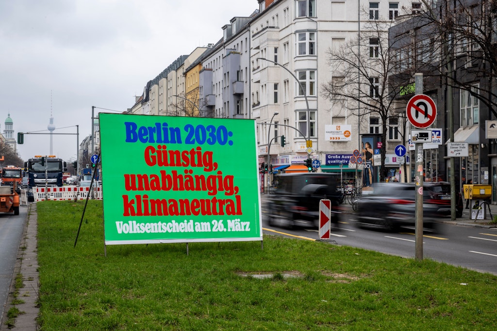 Ein Plakat mit der Aufschrift „Berlin 2030: Günstig, unabhängig, klimaneutral – Volksentscheid am 26. März“ steht auf der Frankfurter Allee.