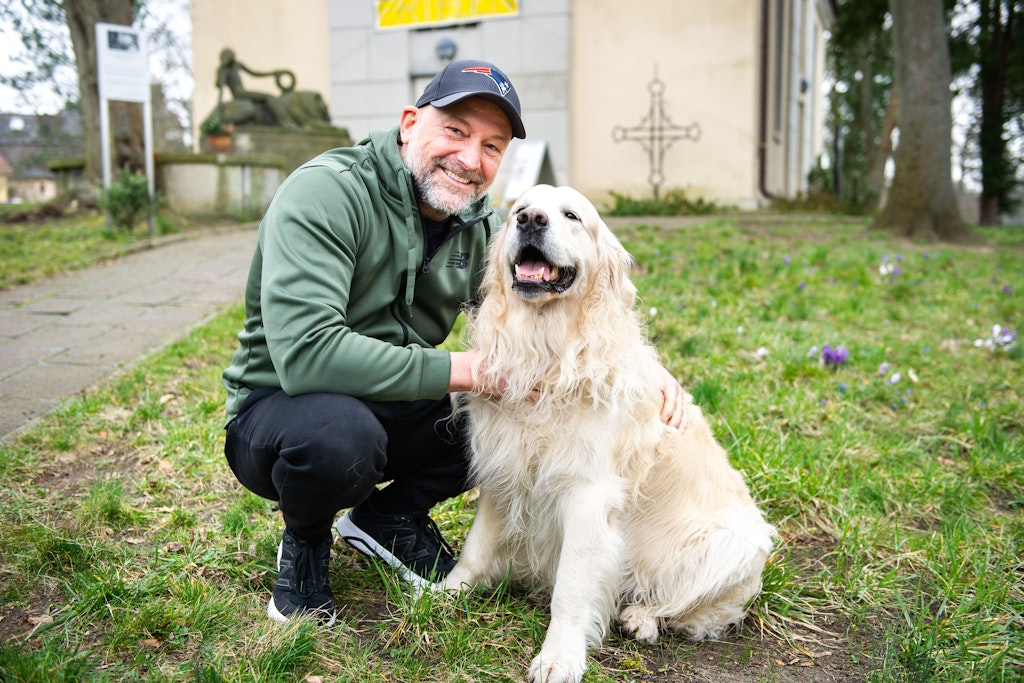 Zurück in der alten Heimat: Björn Casapietra mit seinem Golden Retriever vor der Dorfkirche in Schmöckwitz, in der der Opernsänger seine neue Konzert-Tour durch Deutschland startet.