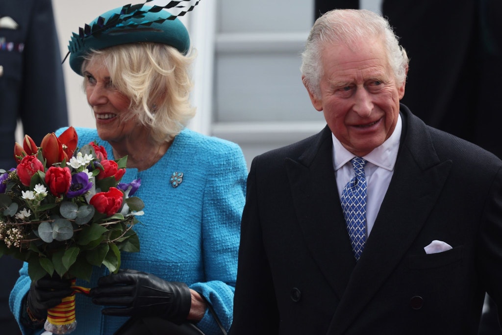 Ein Frühlingsblumenstraß für Camilla: Sie und König Charles III. werden schon am Flughafen BER herzlich begrüßt.