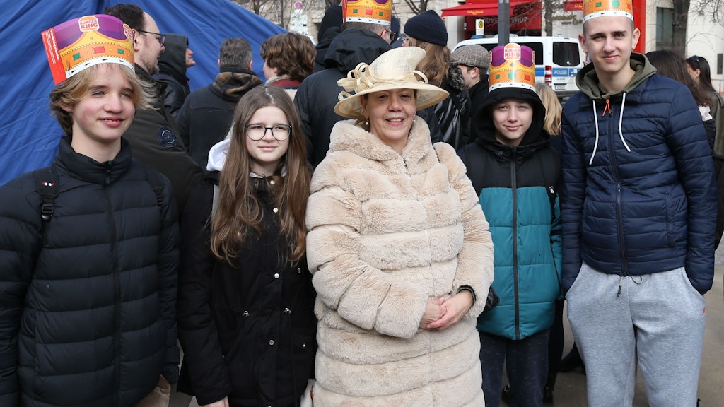 Lehrerin Arlet von Klies mit ihrer Klasse aus Lichterfelde. Die Pappkrönchen ihrer Schüler hat eine Burger-Kette an die Wartenden verteilen lassen. 