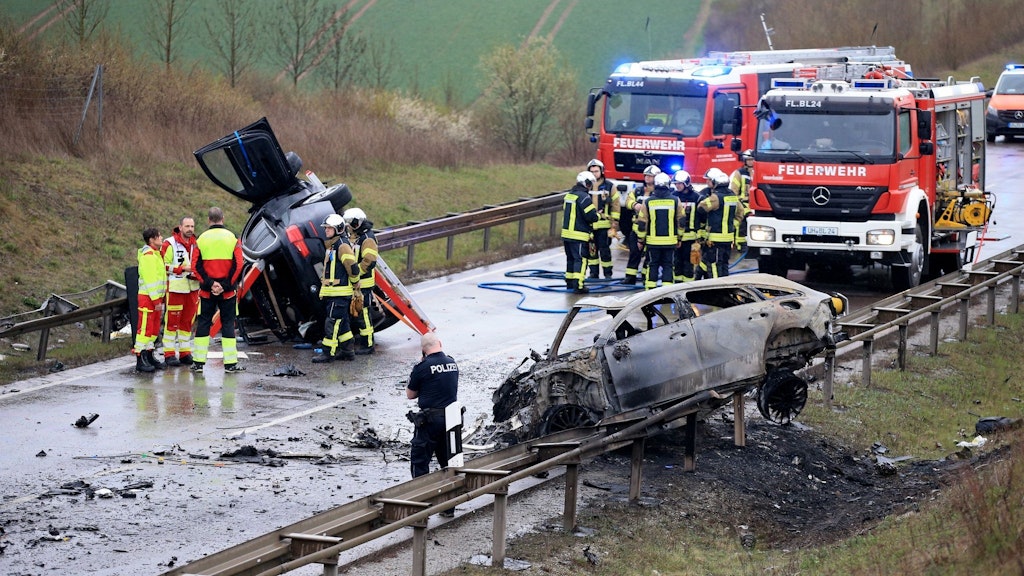 Ein ausgebrannter PKW und ein weiteres Fahrzeug stehen an der Unfallstelle auf der B247 bei Bad Langensalza in Thüringen. 