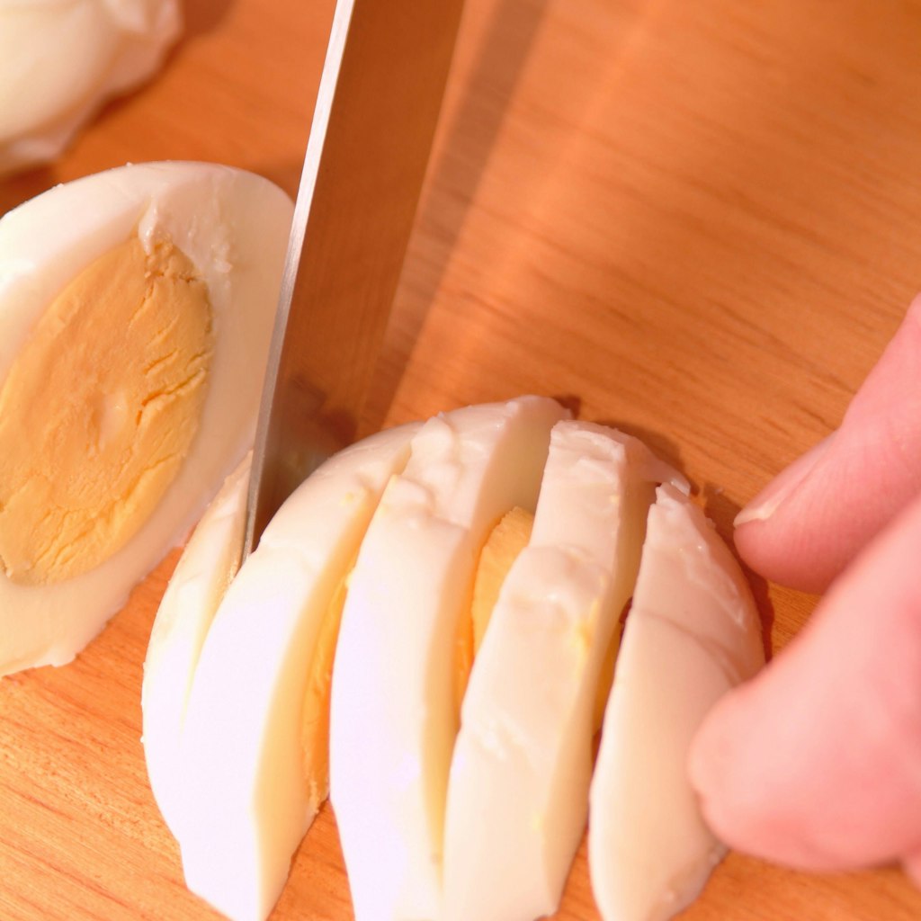 Hartgekochte Eier mit dem Messer in gleichmäßige Scheiben zu schneiden, ist keine einfache Sache, die kaum perfekt gelingt.