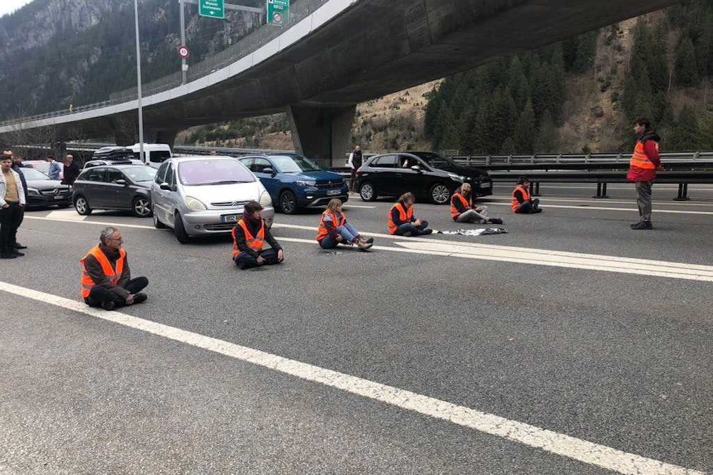 Der Reiseverkehr staut sich bei der Autobahneinfahrt Wassen in Richtung Süden vor dem Gotthard-Tunnel zwischen Güschenen und Amsteg auf mehrere Kilometer. Mitten im Osterverkehrsstau vor dem Nordportal des Gotthardstraßentunnels in der Schweiz haben sich Aktivistinnen und Aktivisten am Karfreitag auf der Fahrbahn festgeklebt. 