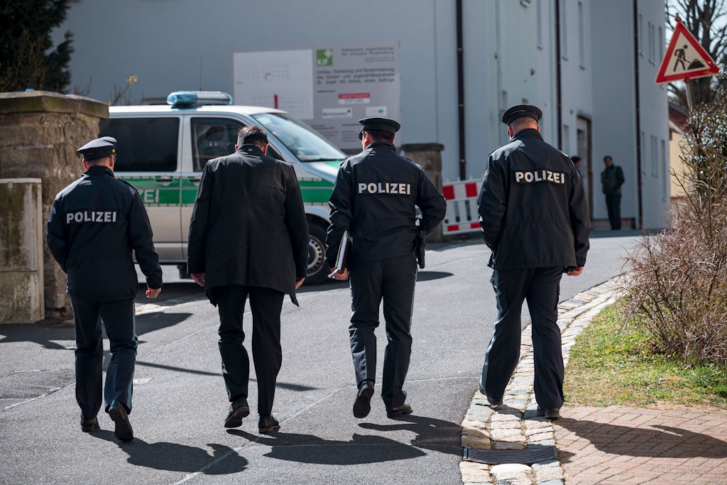 Einsatzkräfte der Polizei gehen in Richtung des Kinder- und Jugendhilfezentrums, wo das Kind getötet wurde.