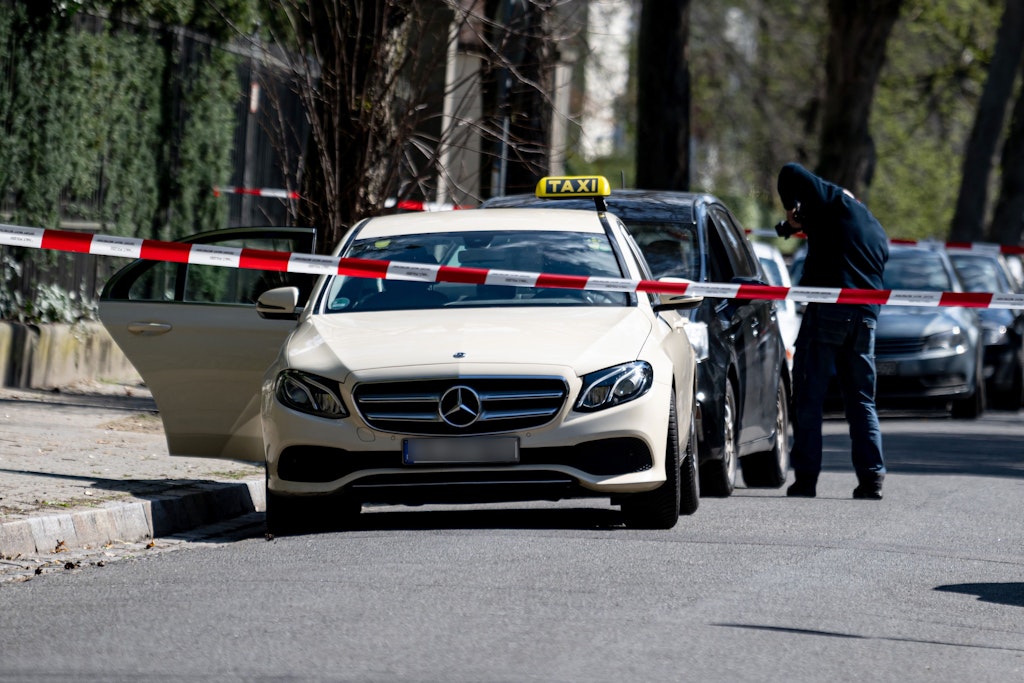 Mitarbeiter der Berliner Polizei am Donnerstag vor dem Taxi in Berlin-Grunewald, dessen Fahrer getötet wurde.