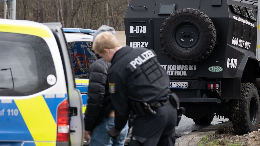 Ein Polizist kontrolliert am Karfreitag einen Mitarbeiter eines polnischen Sicherheitsunternehmens. Das war mit dem gepanzerte Wagen angerückt, sollte im Auftrag des polnischen Spediteurs die streikenden Lkw-Fahrer von ihren Fahrzeugen auf der Raststätte Gräfenhausen-West vertreiben.