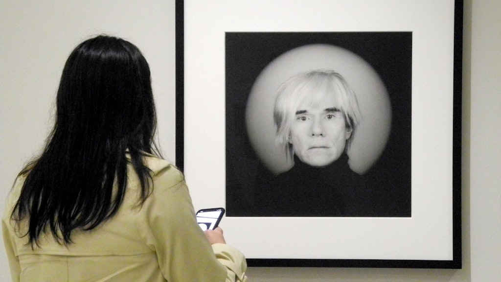 Eine Frau betrachtet bei einer Ausstellung ein Foto von Andy Warhol, das Robert Mapplethorpe (1946-1989) gemacht hatte.