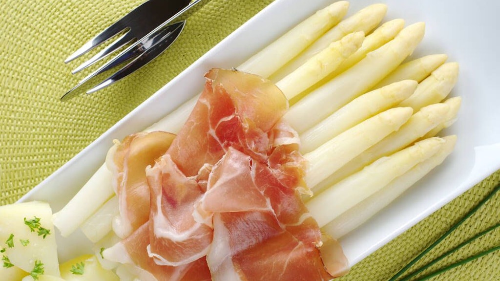 Zu Spargel aus dem Ofen passen Salzkartoffeln und etwas Schinken.