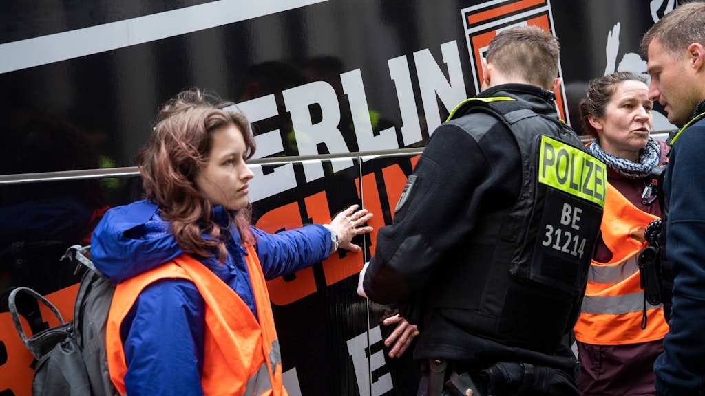 Zwei Klima-Aktivisten haben sich an einen Reisebus vor dem Hotel Marriott am Potsdamer Platz geklebt. 
