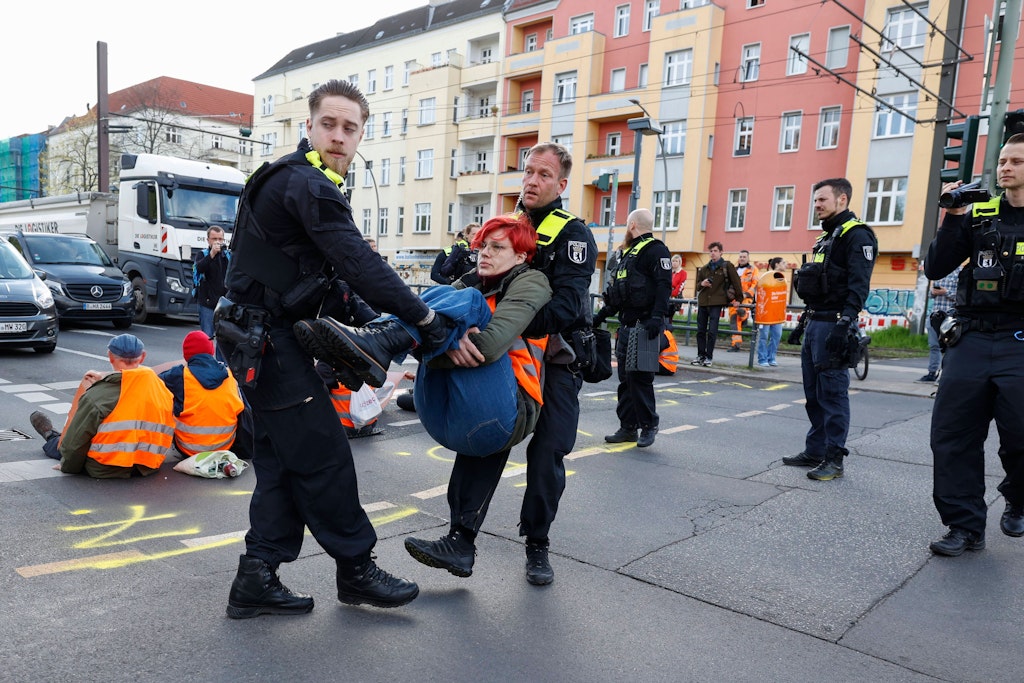 Polizisten tragen eine Aktivistin der Letzen Generation von der Danziger Straße weg. 