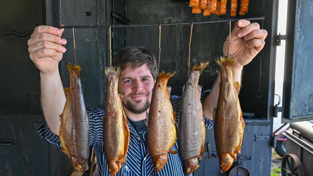Frederik Buhrke, Leiter der Fischerei am Großen Schauener See, mit frisch geräucherten Forellen