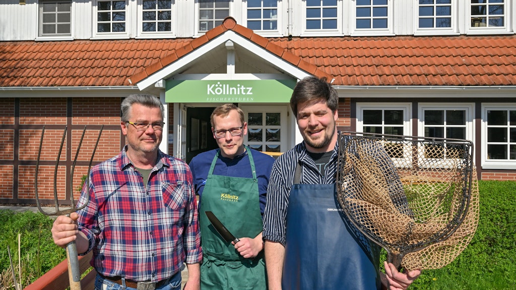Landwirt Jan-Peter Vogel (v.l.), Küchenchef Stefan Ziegenhagen und Fischer Frederik Buhrke vom Naturgut Köllnitz am Großen Schauener See stehen vor dem Restaurant Köllnitzer Fischerstuben.