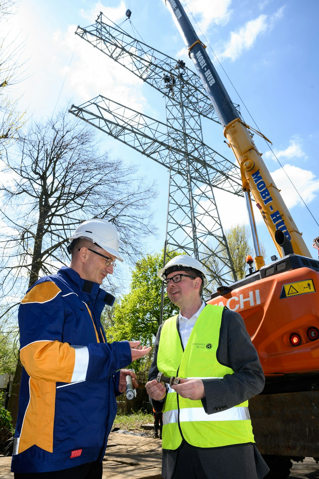 Nr. 5 stirbt ... Ein Kran hebt die ersten Teile des Masts 5 ab, der zur stillgelegten Freileitung vom Kraftwerk Klingenberg zum Netzknoten Wuhlheide führte. Bürgermeister Oliver Igel (r.) und Stromnetz Berlin-Chef Erik Landeck verfolgten die Aktion.