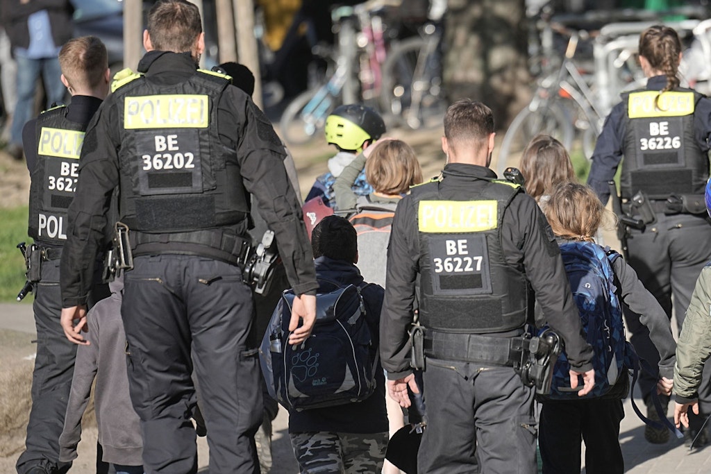 Polizisten geleiten Kinder weg vom Tatort an der Evangelischen Schule in Berlin-Neukölln. Erst Stunden nach der Tat konnten sie zu ihren Eltern. 
