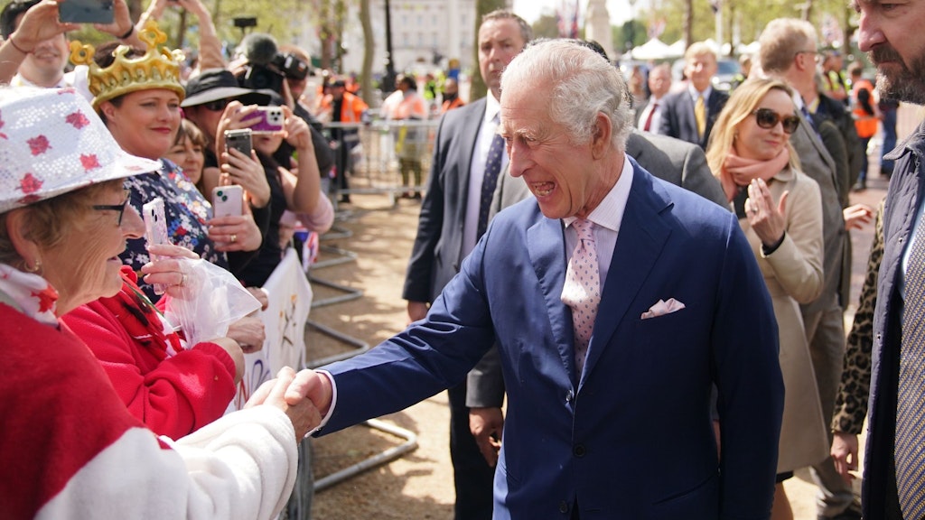 König Charles III. begrüßt am Vortag der Krönung Gratulanten bei einem Rundgang vor dem Buckingham Palast.