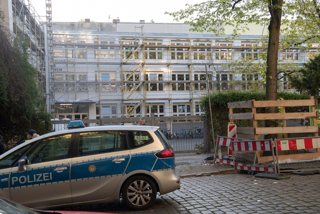 Ein Polizeiwagen steht vor der Schule in Berlin-Neukölln, in der ein Junkie zwei Kinder mit einem Messer attackiert hatte.