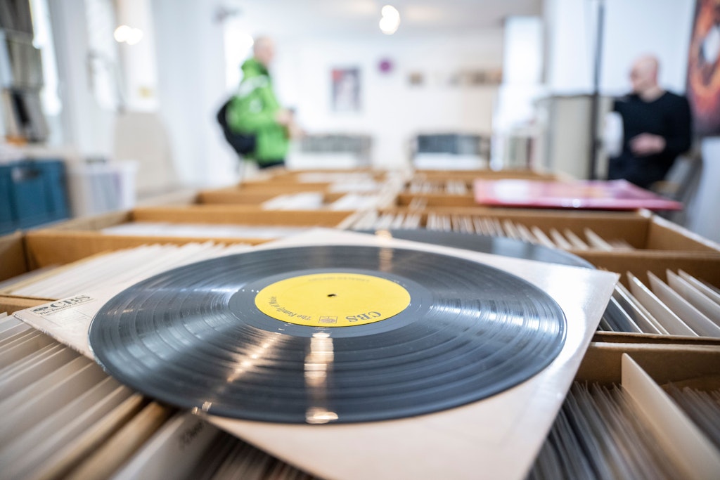 Berlin: Eine Schallplatte liegt auf einer Box mit weiteren Tonträgern. Die Nachfrage nach Vinyl-Schallplatten steigt wieder verstärkt. 