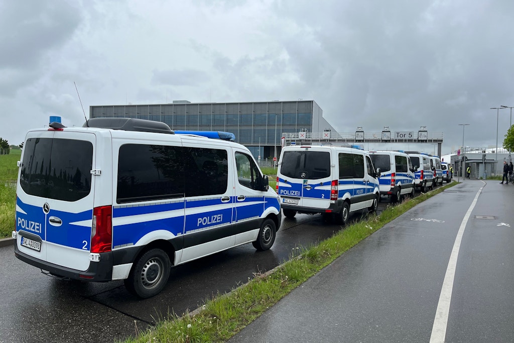 Einsatzfahrzeuge der Polizei stehen an einem Werk von Mercedes-Benz. Auf einem Werksgelände war am Morgen ein Mensch getötet und ein Mensch schwer verletzt worden.