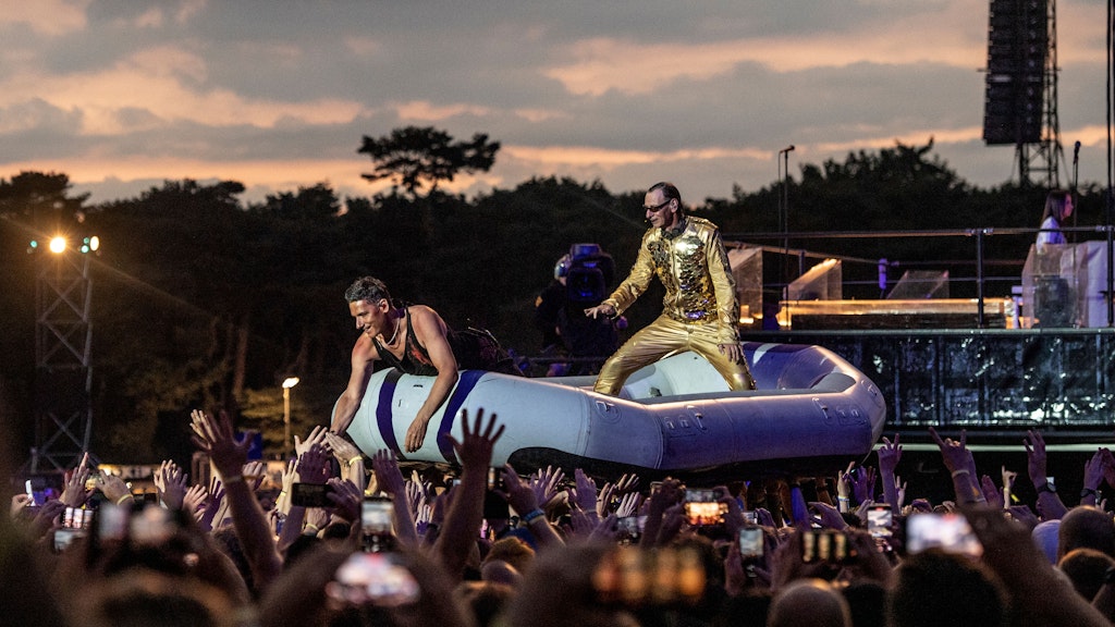 Christian „Flake“ Lorenz, der Keyboarder von Rammstein, und Schlagzeuger Christoph Schneider fahren in einem Schlauchboot durch die Masse der Fans bei einem Konzert.
