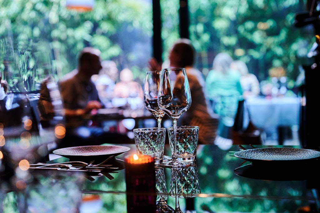 Berlin: Gäste sitzen innen und außen in einem Restaurant. Die bislang kaum übliche Sitte der Reservierungszeitfenster greift jetzt auch in Berlin um sich.