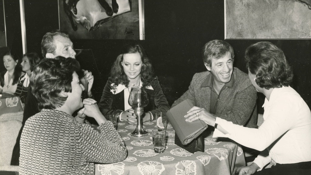 Jean-Paul Belmondo mit der italienischen Schauspielerin Laura Antonelli und Freunden in einem Restaurant (1970). Der französische Filmstar ist der Namenspatron für das Berliner Lokal, das jetzt von Tierschützern angezeigt wurde. 