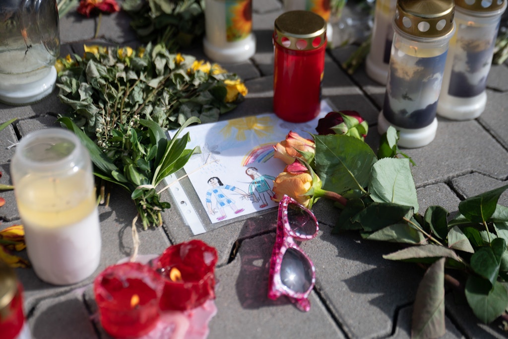 Ein gemaltes Bild mit zwei Kindern liegt vor dem Hochhaus, in dem zwei Kinder getötet wurden.