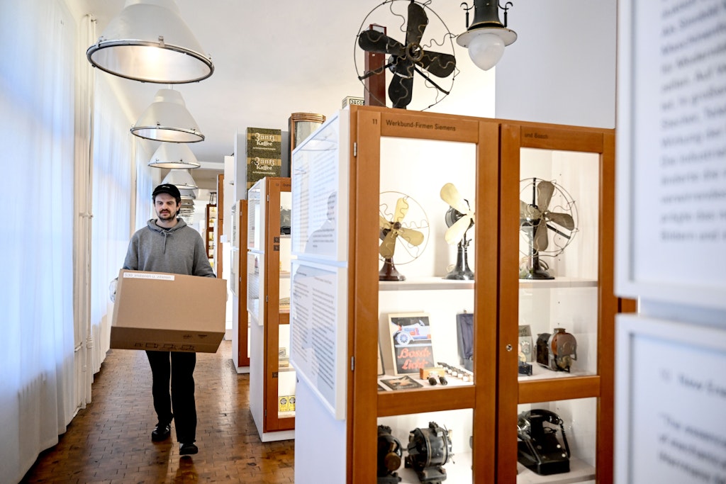 Museumsmitarbeiter Emil trägt im Werkbundarchiv – Museum der Dinge einen Umzugskarton. Das Berliner Museum muss umziehen und schließt deswegen den bisherigen Standort. Die Wiedereröffnung am Interimsstandort in der Leipziger Straße ist für Mai 2024 geplant.