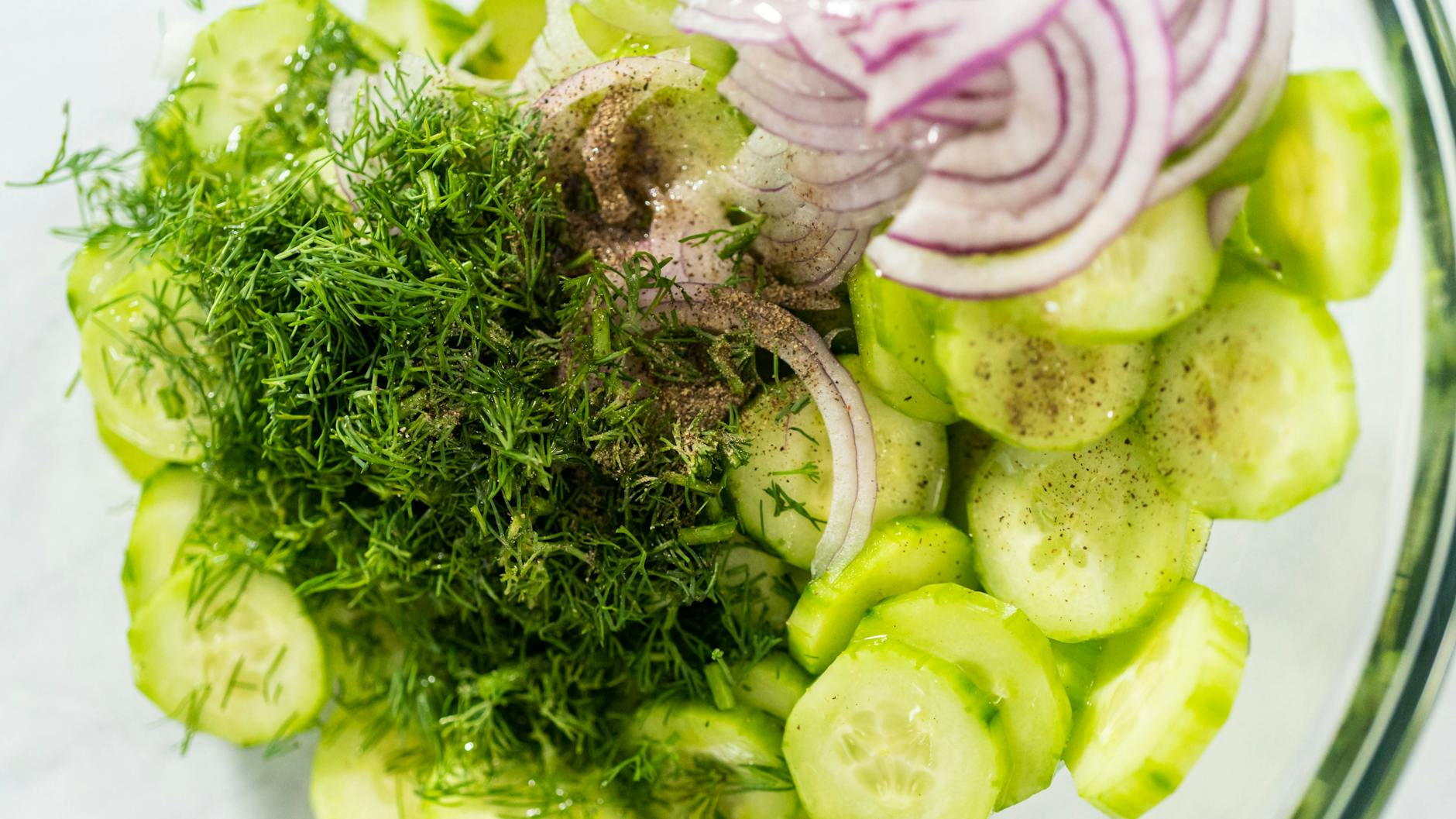 Gurken, Zwiebeln und ein paar einfache Zutaten für das Dressing: Mehr braucht es nicht für einen leichten und frischen Gurkensalat mit Zwiebeln aus der DDR. So hat ihn schon Oma geliebt!