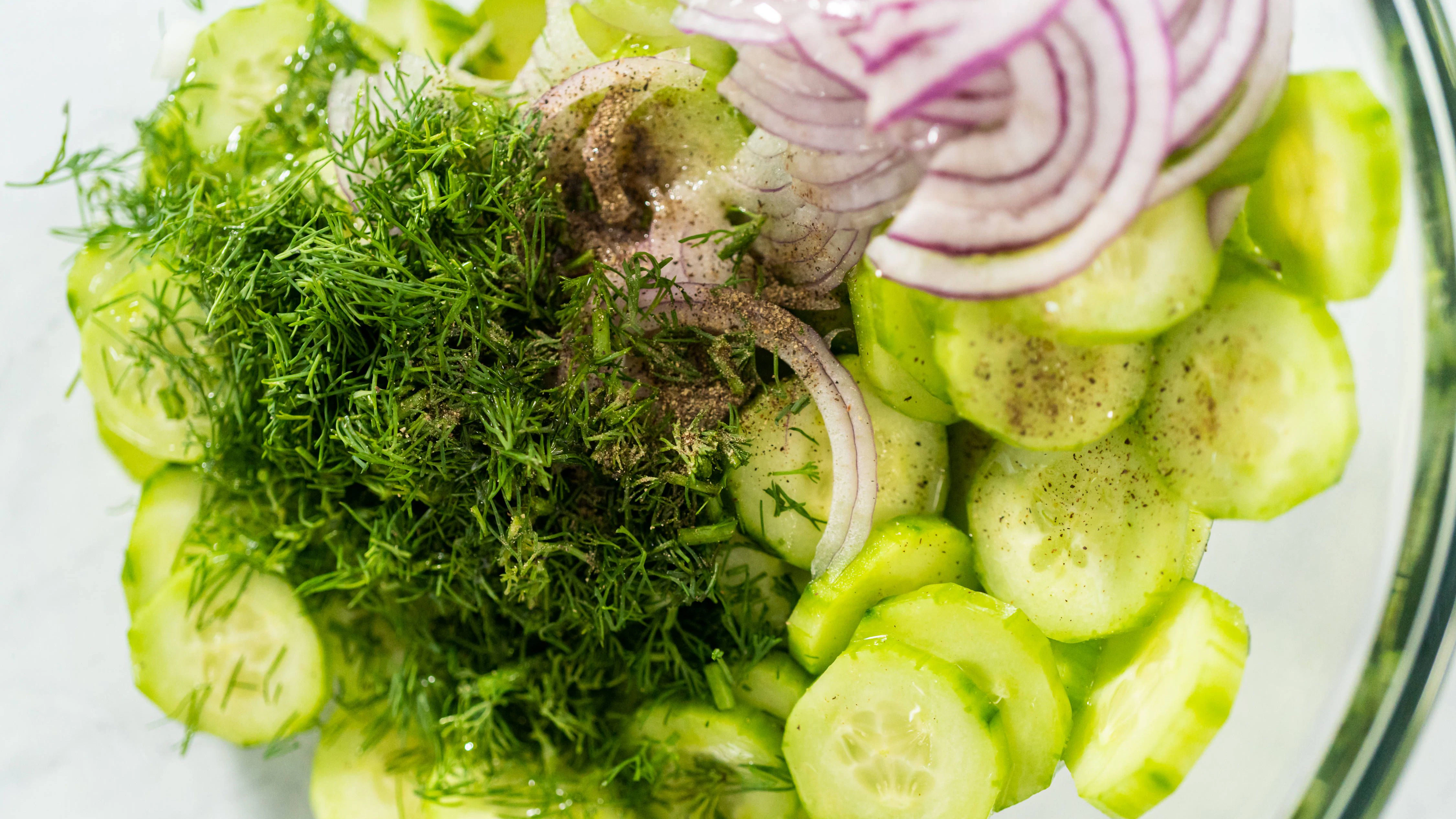 Gurken, Zwiebeln und ein paar einfache Zutaten für das Dressing: Mehr braucht es nicht für einen leichten und frischen Gurkensalat mit Zwiebeln aus der DDR. So hat ihn schon Oma geliebt!