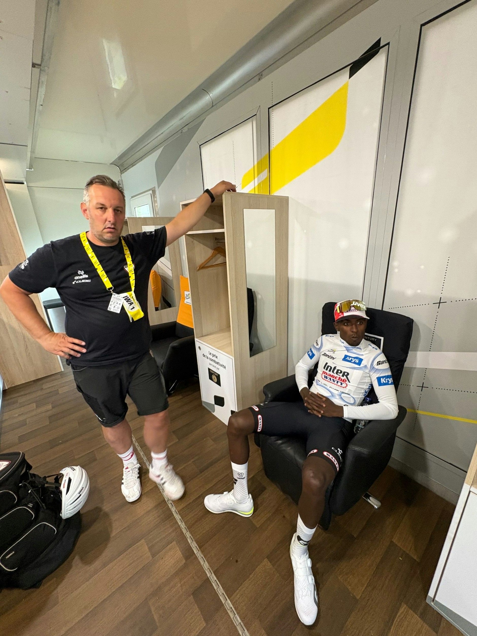 Soigneur Steven steht entspannt, Sprintstar Biniam Girmay sitzt noch lässiger. Vor dem Gang aufs Podium ist alles schick angerichtet.
