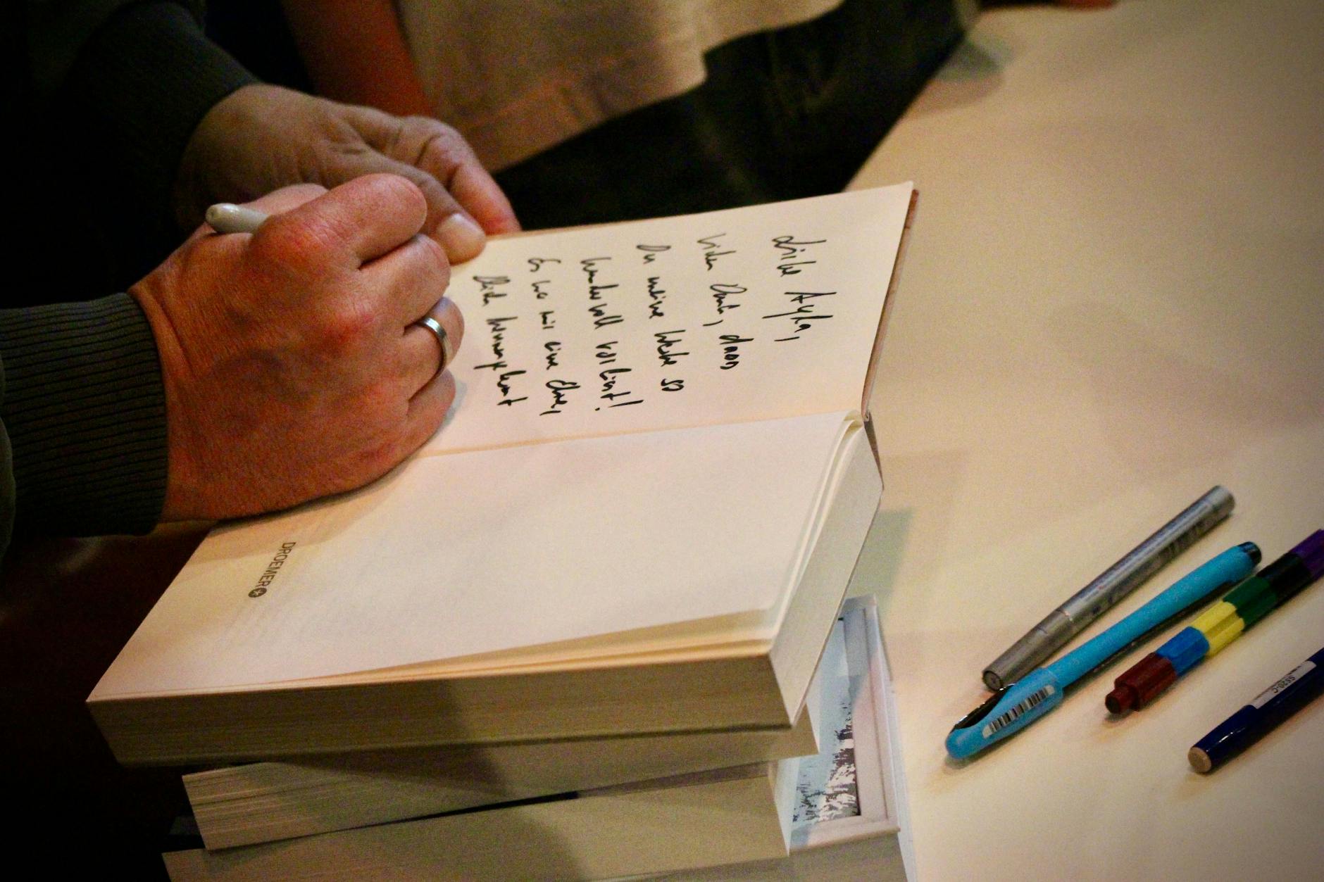 Nach der Lesung: Sebastian Fitzek schreibt und schreibt Autogramme für alle – und hier für Ayla.