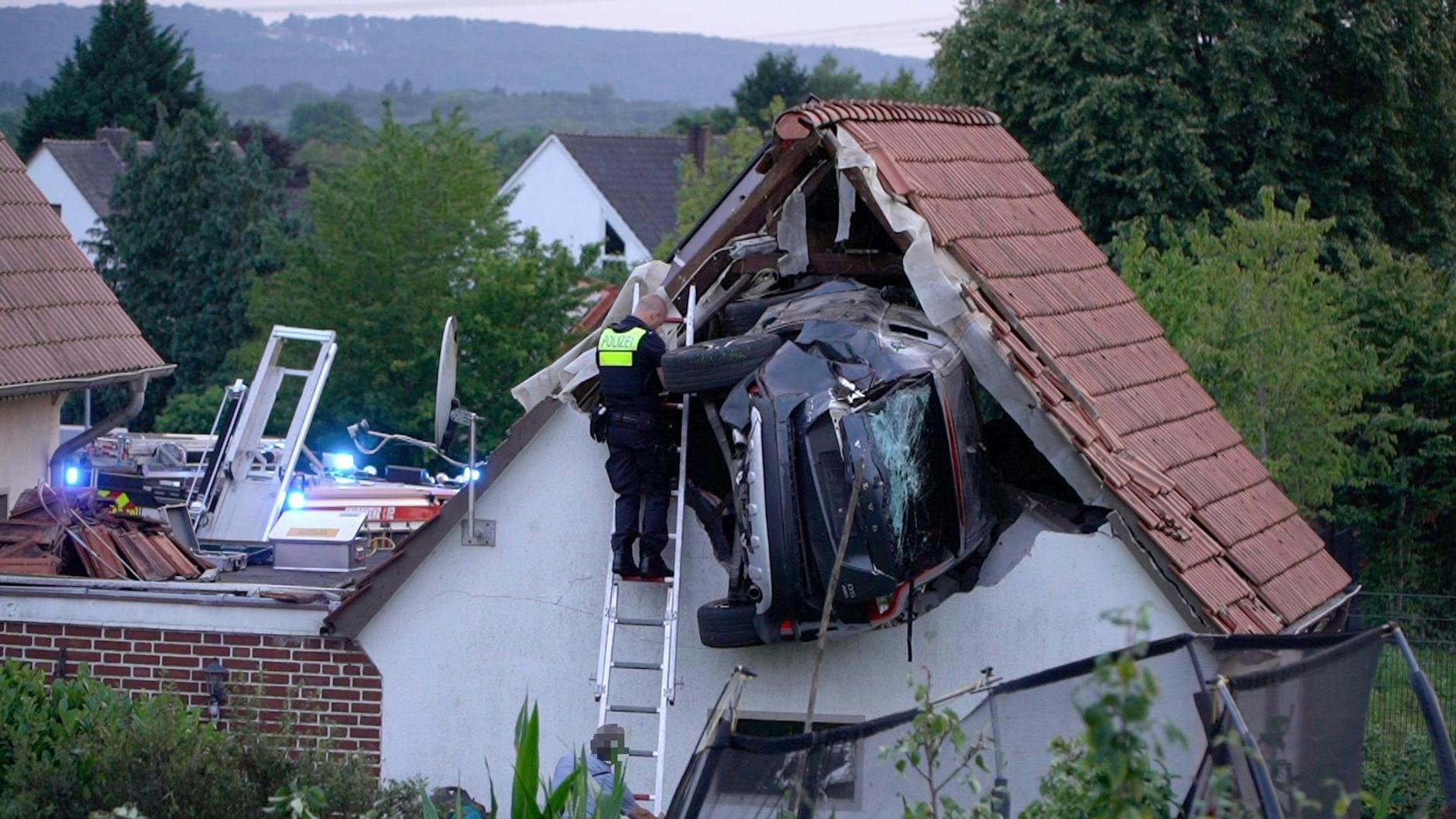 Ein Polizist steht auf der Leiter neben dem Auto, das in die Scheune gkracht war. Rechts im Vordergrund ist die Umrandung des Trampolins zu sehen, auf dem der siebenjährige Junge gespielt hatte.