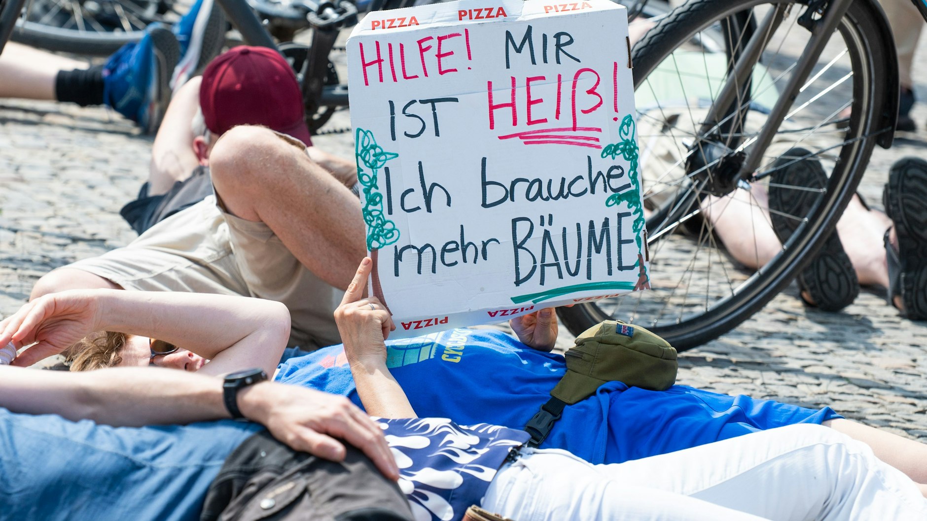 Rund 60 Menschen simulierten am Sonntag vor dem Brandenburger Tor den Hitzetod. Sie kämpfen damit unter anderem für mehr Straßenbäume und Grünflächen.