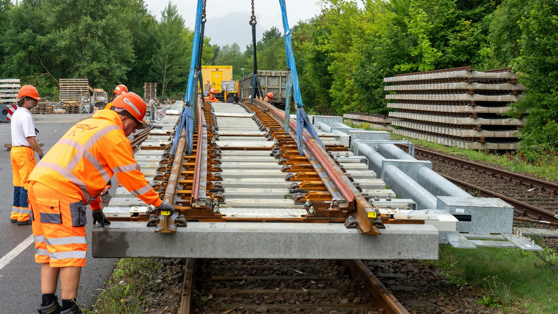 Arbeiter transportieren bei Brieselang mit Hilfe eines Eisenbahndrehkrans eine fertig montierte Weiche für den Ausbau der Bahnstrecke Berlin - Hamburg.