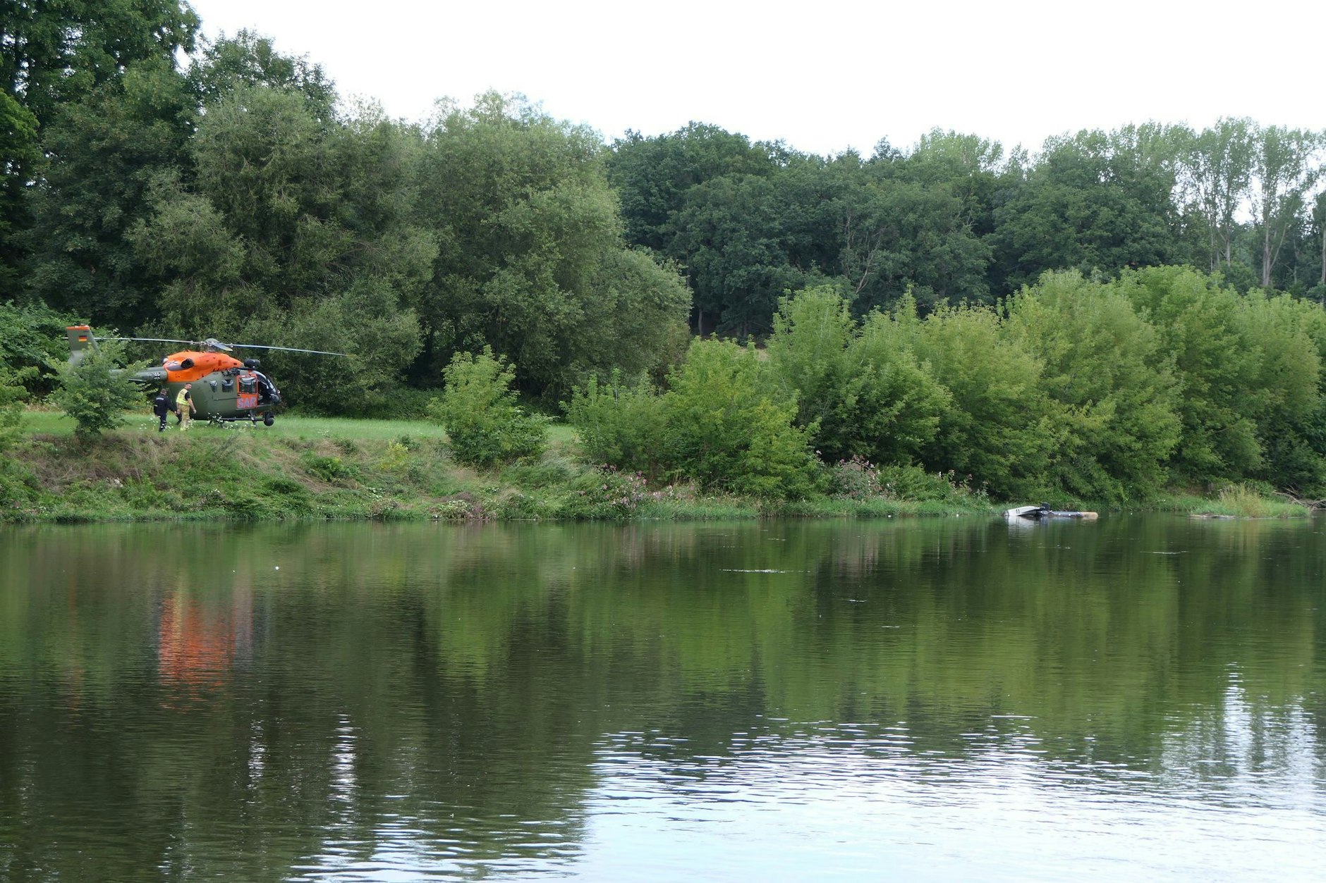 Ein Hubschrauber (rechts) treibt in der Nähe von Grimma in Sachsen in der Mulde.