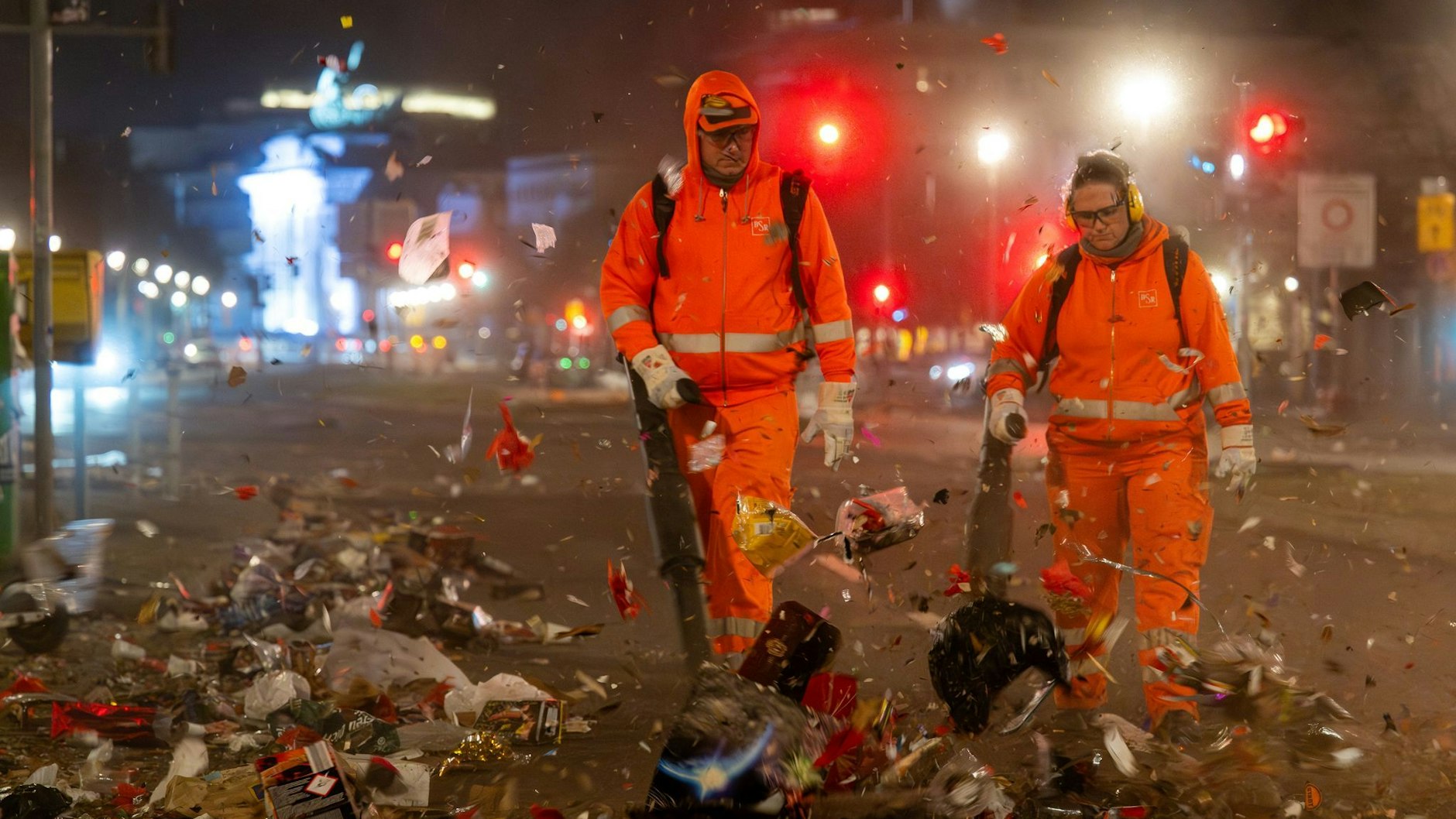 Mitarbeiter der Berliner Stadtreinigung (BSR) blasen mit Laubbläsern den Müll der Silvesternacht auf die Ebertstraße.