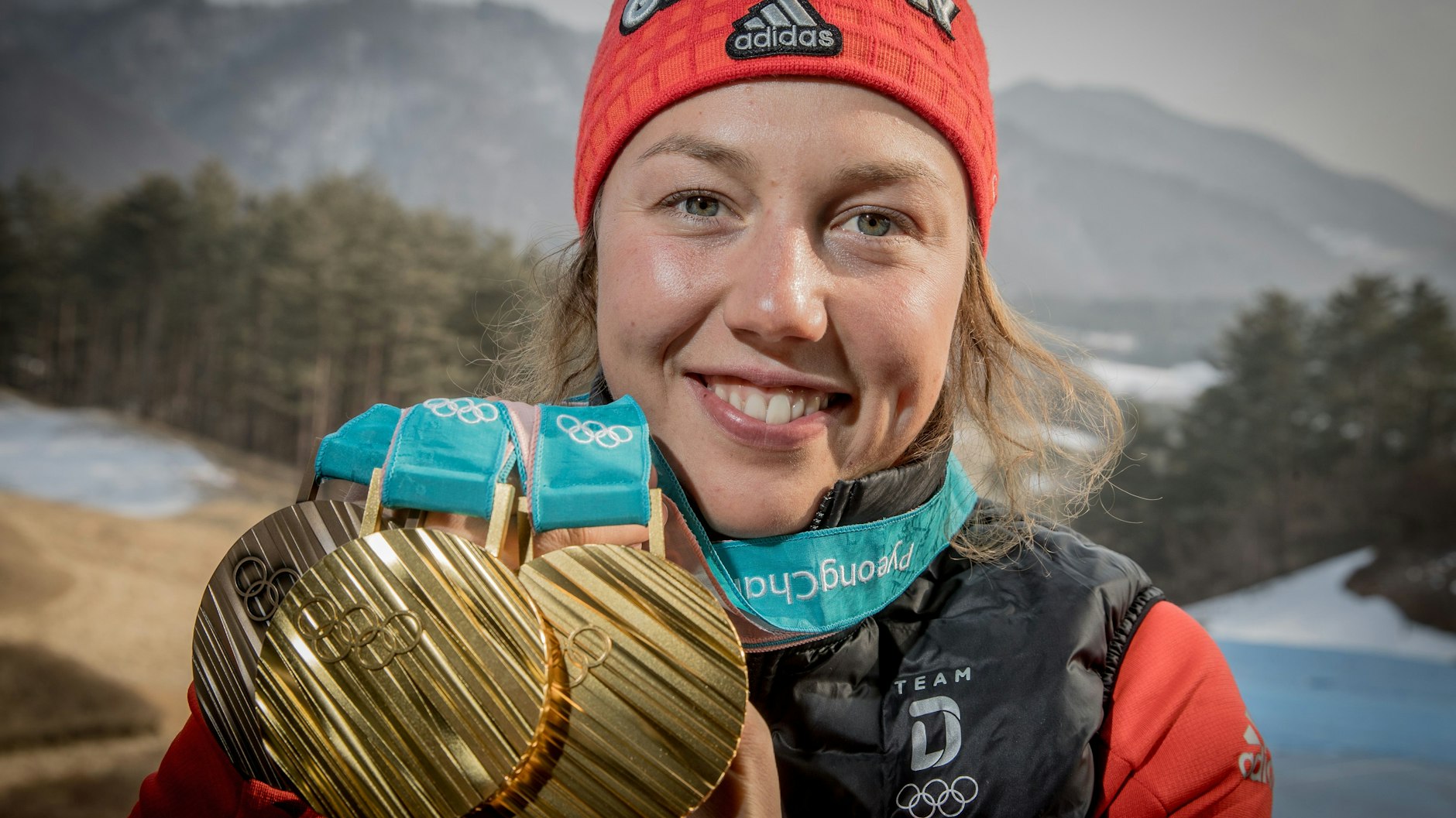Laura Dahlmeier zeigt ihre Medaillen, die sie bei den Olympischen Spielen 2018 gewonnen hat.