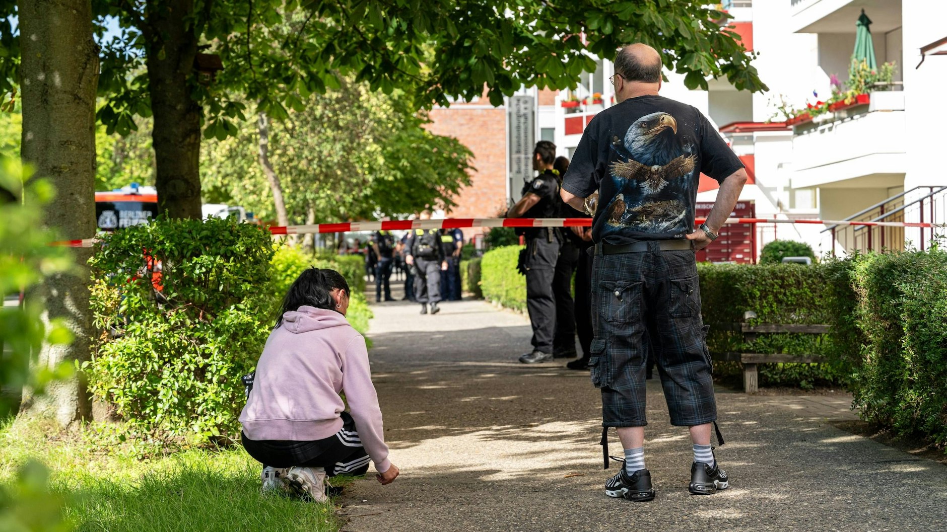 Anwohner beobachten hinter der Absperrung das Geschehen.