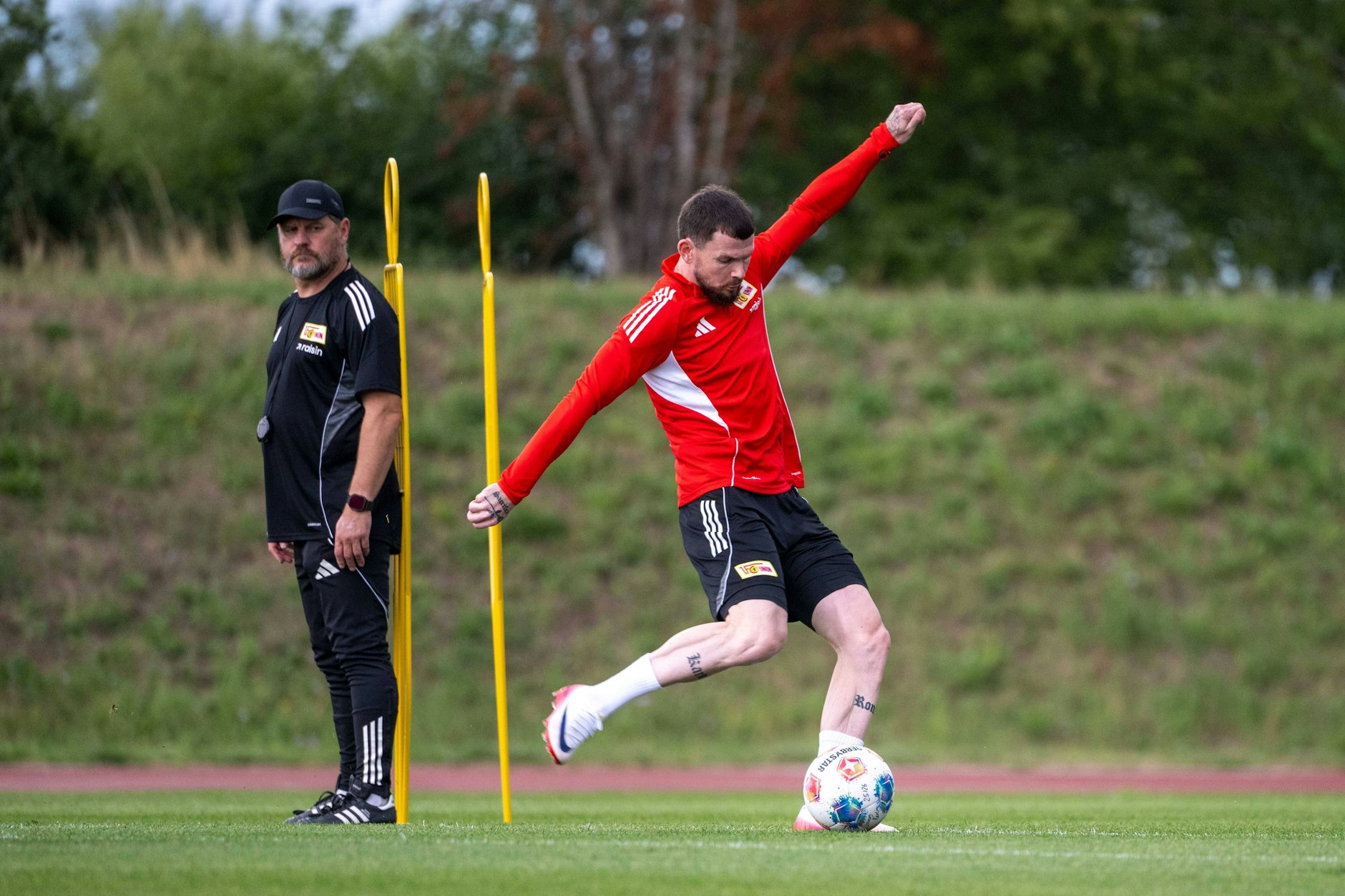 Steffen Baumgart (53) macht sich im Training einen Eindruck von Neuzugang Oliver Burke (28). Der Schotte soll am Sonnabend gegen Piräus die Tor-Krise in Köpenick beenden.