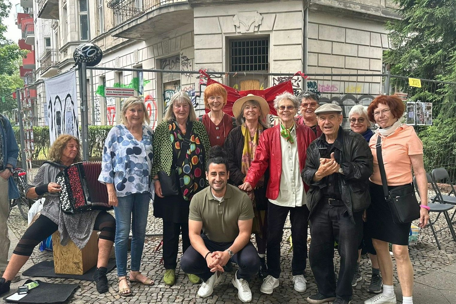 Monika K. (v.r.n.l.), Birgit L., Atze, Stefania d. M., Sabine K., Ursula P., Ingrid Schipper, Mary S., Andrea F. Vorne hockt Orkan Özdemir (SPD), der sich für drei Häuser in Berlin, darunter auch das Geisterhaus in Friedenau, einsetzte.