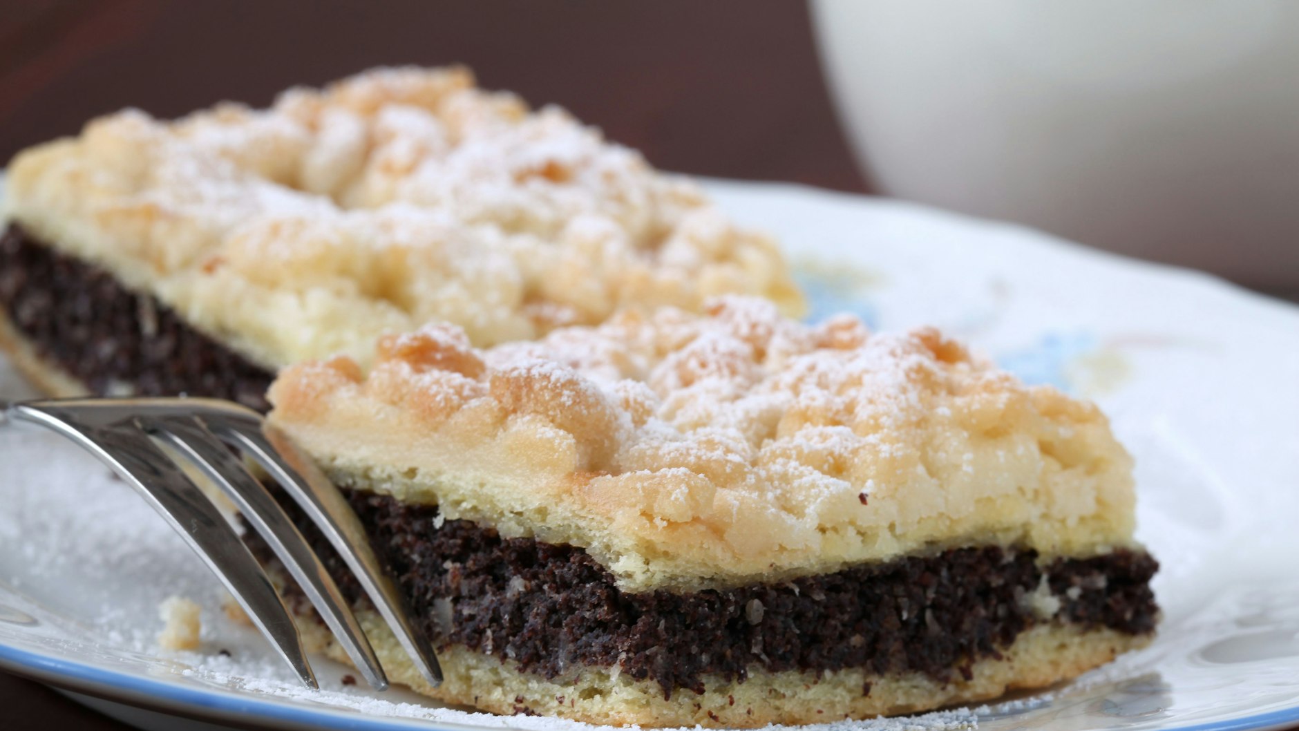 Mohnkuchen mit Streuseln gibt es in verschiedenen Varianten. Ob schlicht wie hier oder mit dicker Pudding-Füllung: für Naschkatzen ist so ein leckerer Kuchen genau richtig.