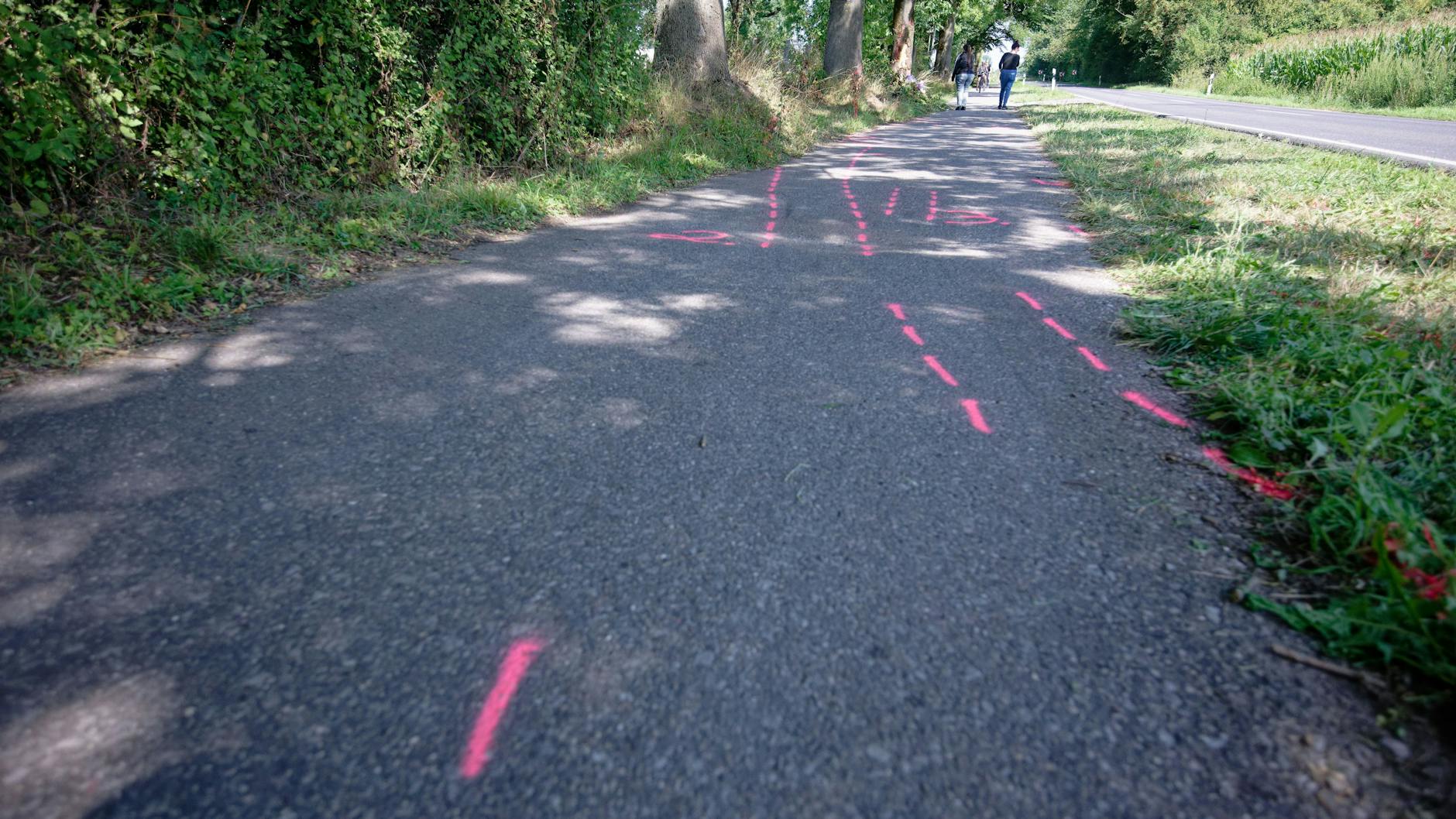 Rote Markierungen der Spurensicherung zeigen an der Unfallstelle zwischen Monheim und Düsseldorf den Weg des Unfallwagens. Bei dem Unfall starben eine 17-Jährige und ein 15-Jähriger. Drei weitere Insassen des Unfallfahrzeugs wurden schwer verletzt.