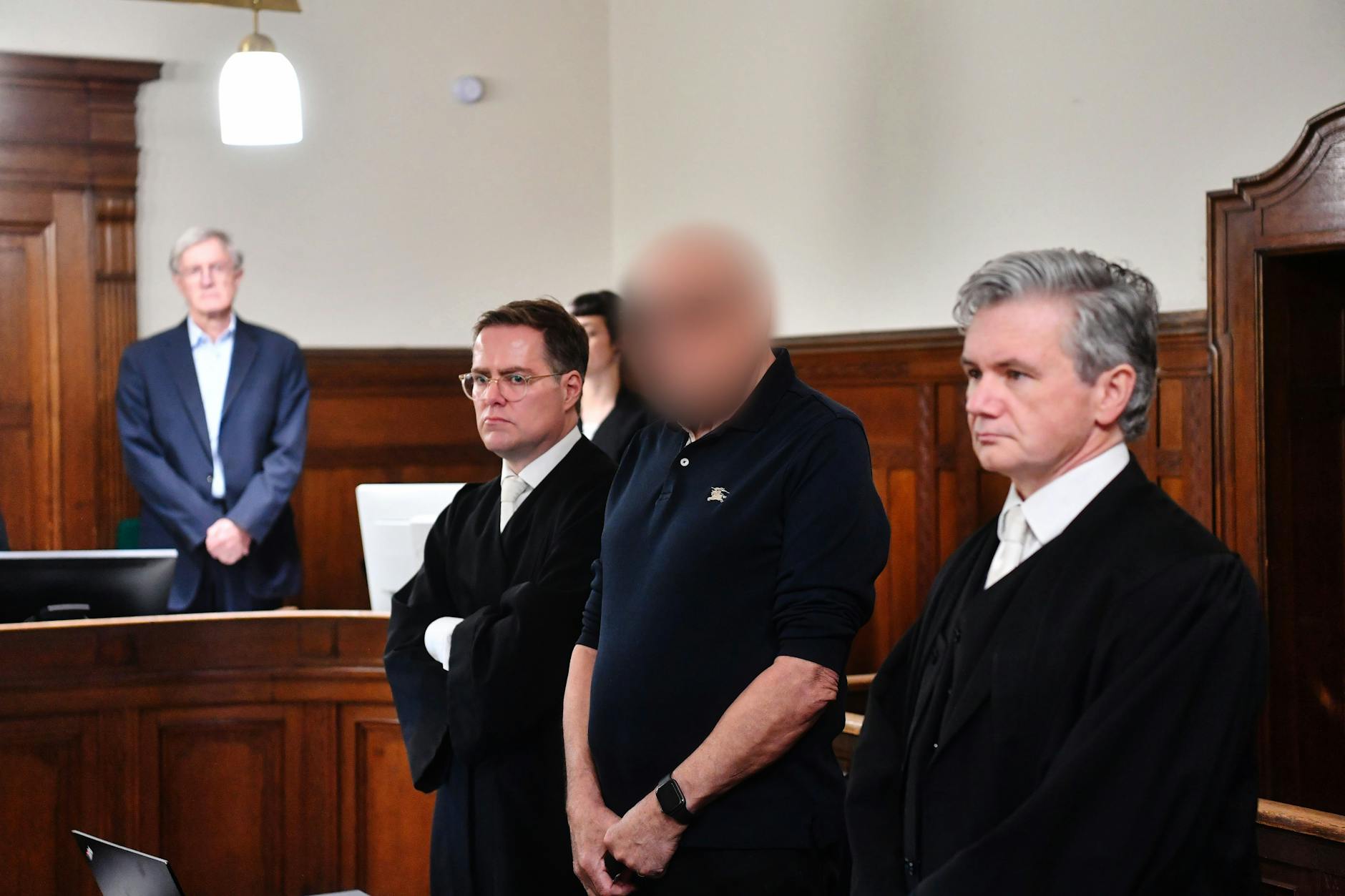 Der Angeklagte steht im Gerichtssaal des Kriminalgerichts beim Prozessauftakt. Der Narkosearzt soll für den Tod einer 59-jährigen Patientin verantwortlich sein. Jetzt schickt die Richterin den Arzt in den Knast.