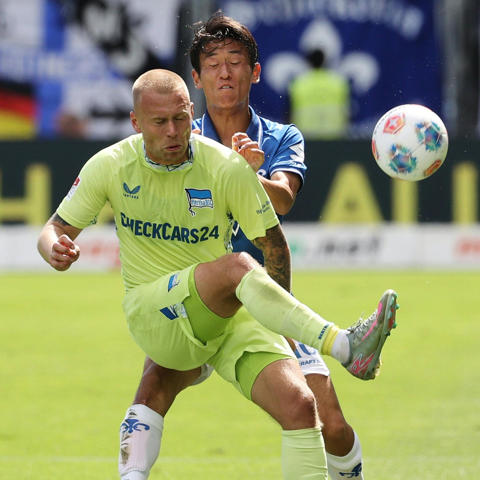 Herthas Isländer Jon Thorsteinsson im Zweikampf mit Darmstadts Hiroki Akiyama.